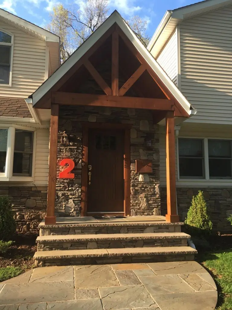 Stone and timber framed entry portico with bluestone steps on a Bergen County home
