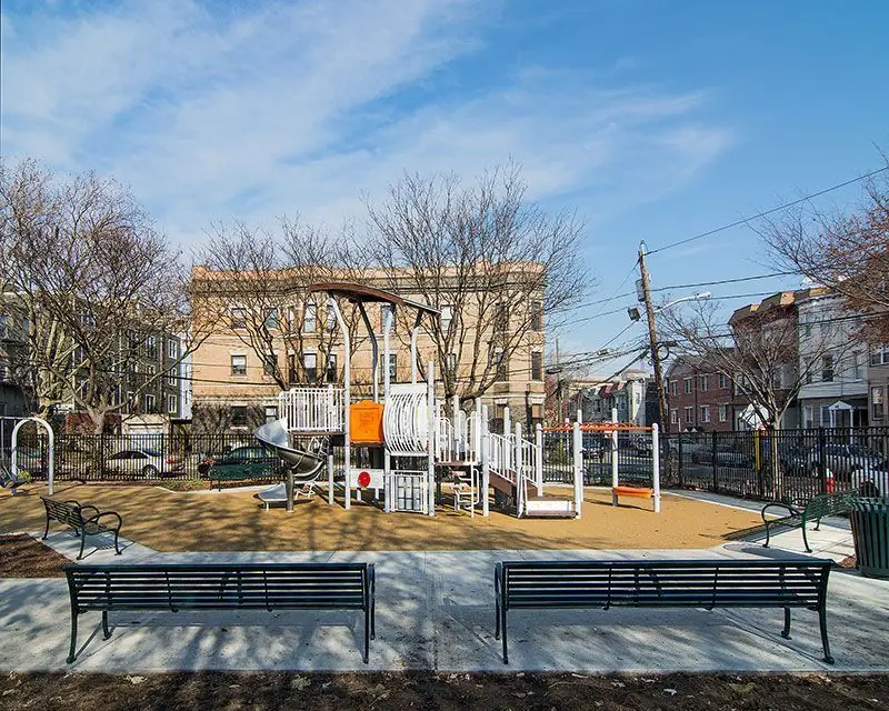Poured concrete walkway and bench pads at a municipal playground built by Adamo Brothers